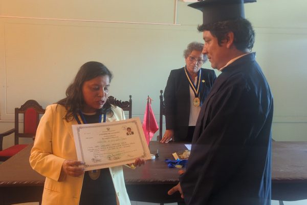 Dra. Nilda Janet Mallqui Cruz entregando el titulo y felicitando al recien titulado Delgado Silva Abel Abelardo.